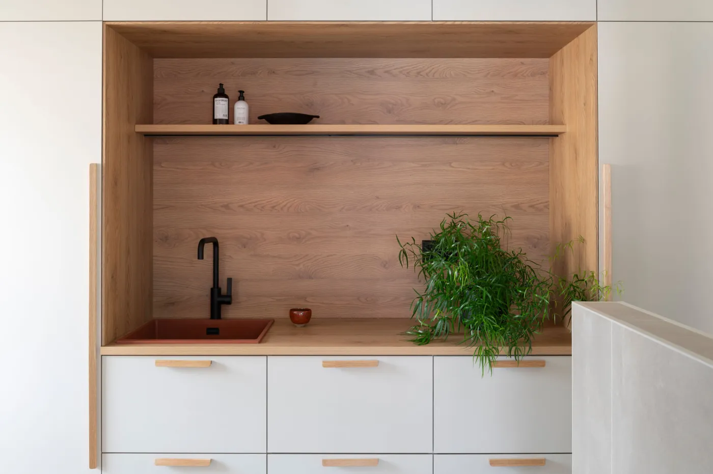 Beige kodinhoitohuone tammitasolla ja -vetimillä sekä terrakotan sävyisellä altaalla.